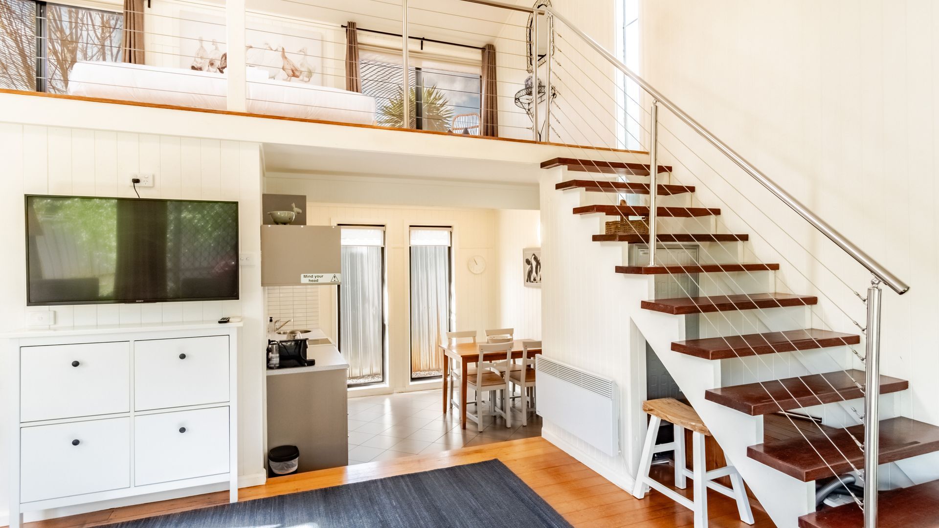 A modern interior with a staircase, a kitchen area, and a dining space.