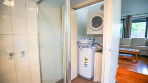 A laundry room with a washing machine, a dryer, and a utility room.