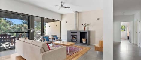 A modern living room with a sofa, coffee table, and fireplace.
