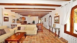 Ein geräumiger Wohnbereich mit Sofa, Couchtisch und einem Essbereich mit Tisch und Stühlen.