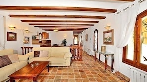 A spacious living area with a sofa, coffee table, and a dining area with a table and chairs. - Villa Tranquila (Moraira)