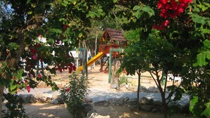 A playground with a slide, climbing structures, and a small house-like playhouse. - Charming Penthouse, FREE INTERNET, CABLE and SAFE DEPOSIT BOX (Playa del Carmen)