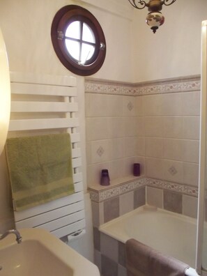 A bathroom with a white sink, a green towel, a shower with a white tub, and a decorative wall tile border. - PRIME VIEW on OLD HARBOUR. Refurbished. Wifi, GARAGE on option, Cleaning +linen (Honfleur)