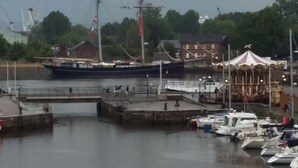 A harbor with a large sailing ship docked, a carousel, and several smaller boats. - PRIME VIEW on OLD HARBOUR. Refurbished. Wifi, GARAGE on option, Cleaning +linen  (Honfleur)