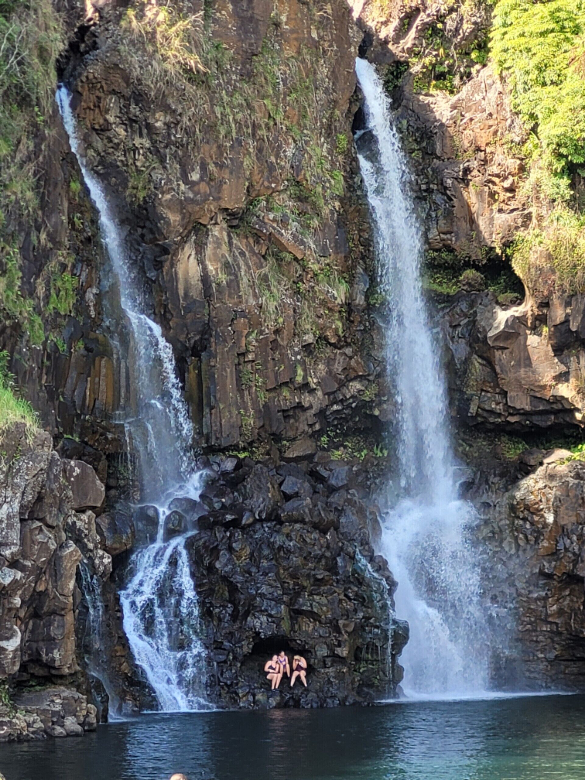 A waterfall with two distinct streams cascading down a rocky cliff.