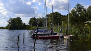 A calm water body with boats docked, surrounded by greenery and trees. - Year-round relaxation in a Danish holiday home with a fireplace in Gartow am See  (Gartow)