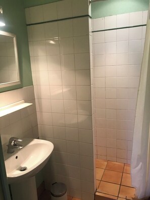 A bathroom with a sink, mirror, and tiled walls.