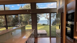 A modern kitchen with large windows, a built-in oven, and a view of the outdoors. - Coast@Culburra -  newly renovated  - luxurious beachfront house with spa (Culburra)