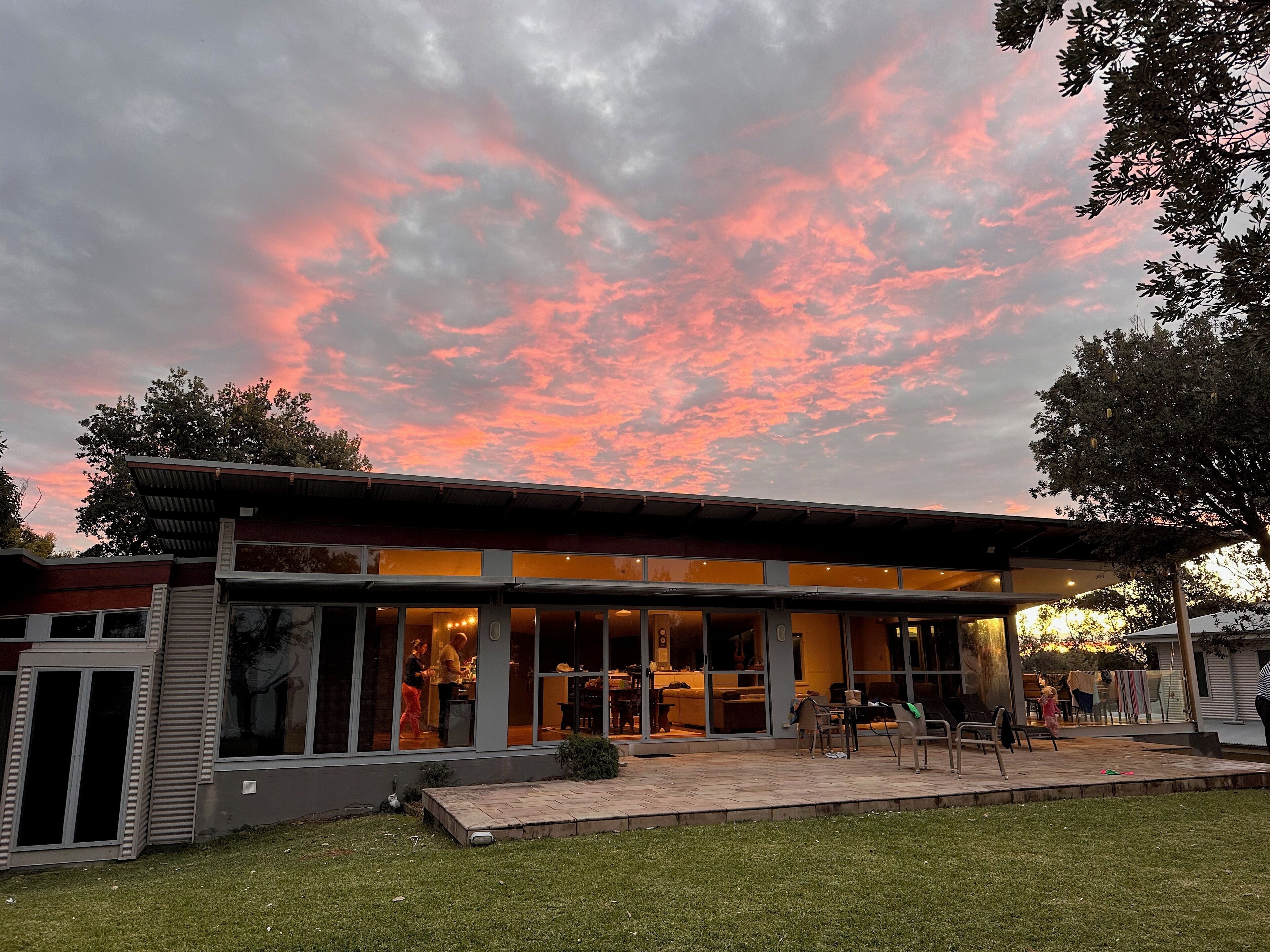 A modern building with large windows and a covered patio area.