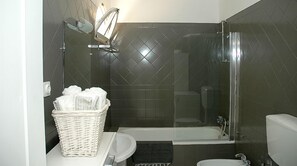 Tina con regadera, secadora de cabello, bidet, toallas 