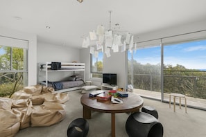 Une chambre moderne avec un lit superposé, une télévision et un balcon offrant une vue agréable.