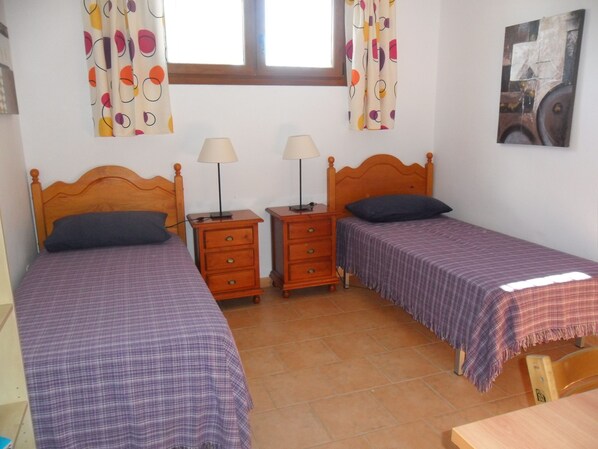 A room with two single beds, wooden nightstands with lamps, a window with curtains, and a painting on the wall. - Villa with 10 by 4 meter private pool, Nerja & Beaches 5 min (Nerja)