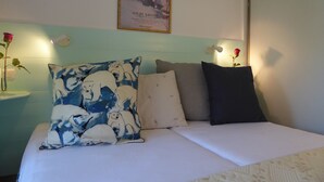 A bed with a white sheet and three pillows, a framed picture on the wall, and a vase with a rose on the nightstand. - "Côté Jardin" .... absolute calm in the center of Cannes ... with garage (Cannes)
