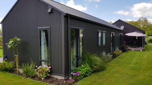 Un bâtiment moderne à l’extérieur sombre, doté de grandes fenêtres et d’une antenne parabolique.