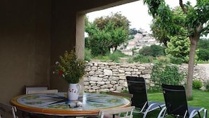 Eine Außenpatio mit einem runden Tisch, Stühlen und einem Blumentopf.