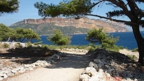 A rocky path leading to a coastal area with pine trees and a view of a cliff and the sea. - guest rooms 4 persons near the sea & Sainte Victoire (Trets)