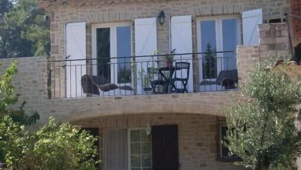 A two-story stone building with a balcony, outdoor seating, and a view of trees. - guest rooms 4 persons near the sea & Sainte Victoire (Trets)