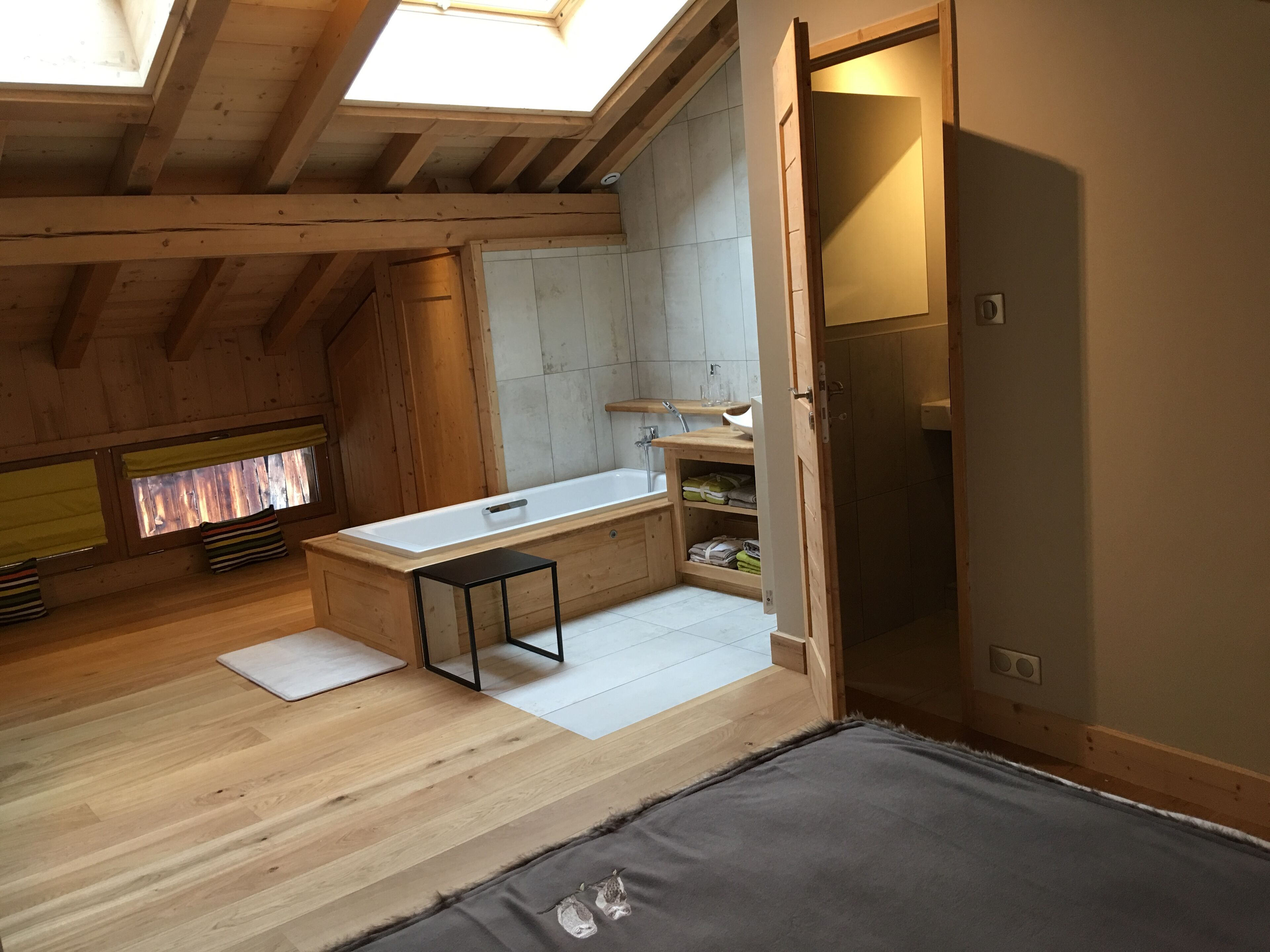 Ein gemütlicher, hölzerner Innenraum mit einer Dachfenster, einem kleinen Tisch und einer integrierten Sitzbank.