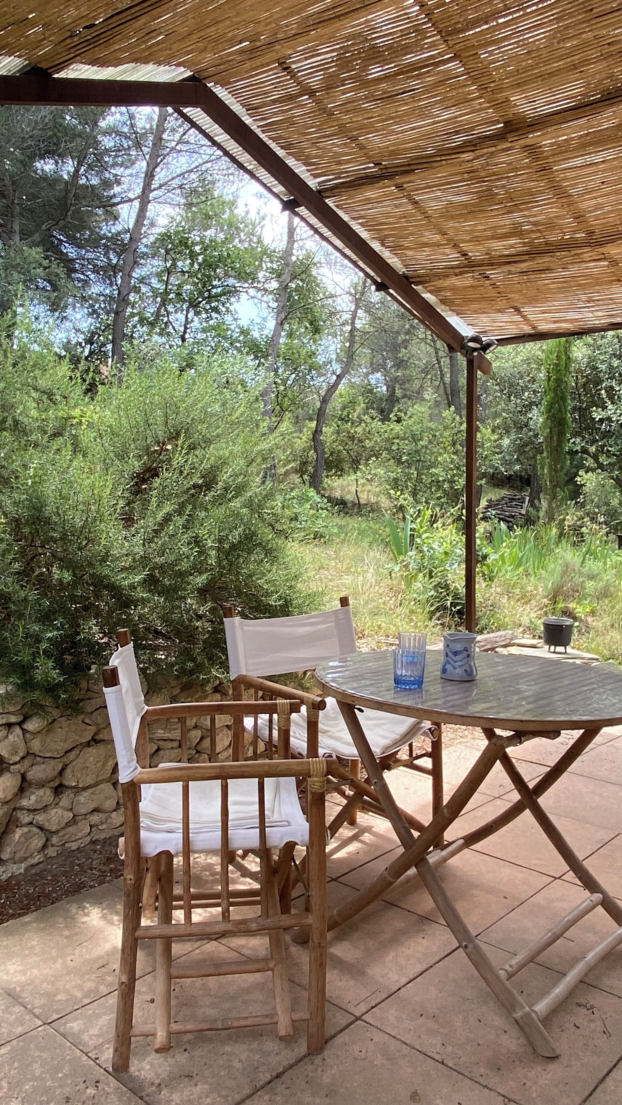 Un espace de restauration en plein air avec une table et des chaises sous une pergola en bois.