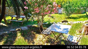 Ein Garten mit Picknicktischen und einer Steinmauer.