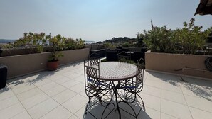A rooftop terrace with a round table and chairs, surrounded by potted plants and overlooking a scenic view. - Rare product (T3) in the heart of Cavalaire  (Cavalaire-Sur-Mer)