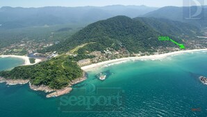 An aerial view of a coastal area with a beach, a small island, and a dense forested mountain. - Juquehy Condominium Oceanfront 42: best location on the beach  (Praia de Juqueí)