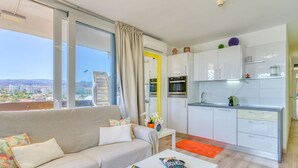 Ein modernes Wohnzimmer mit einer Couch, einem Couchtisch und Blick auf die Stadt.