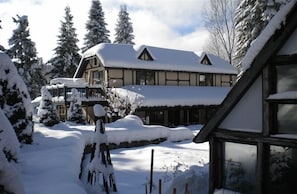 A snow-covered lodge with a large central building and a smaller structure to the left. - Dragon's Lair / Garden Loft, Very Private, Cov. Gar. 1 BR. 1 BA. 1 Mi to MS. (Mt Shasta)