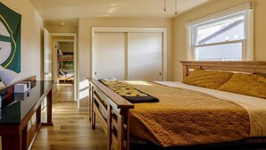 A bedroom with a bed, a wooden headboard, a window, a closet, and a hallway leading to a door labeled "PACKERS". - Oneida St duplex 5 min walk to Lambeau 8 beds furnished full kitchen laundry (Green Bay)