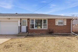 A single-story brick house with a garage, a front porch, and a small front yard. - Classic Oneida Tailgate House - 5 minute walk to Lambeau (Green Bay)