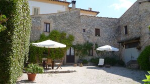 A courtyard with stone buildings, outdoor seating, and potted plants. - Cacciarella elegant and independent holiday apartment to rent  2+2 pax (Arezzola)