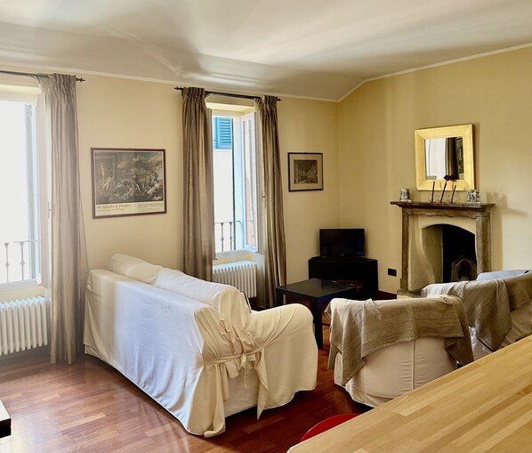A hotel room with two beds, a fireplace, a television, and artwork on the walls. - Charming romantic apartment in an ancient villa in Bellagio, close to lakeshore (Bellagio)