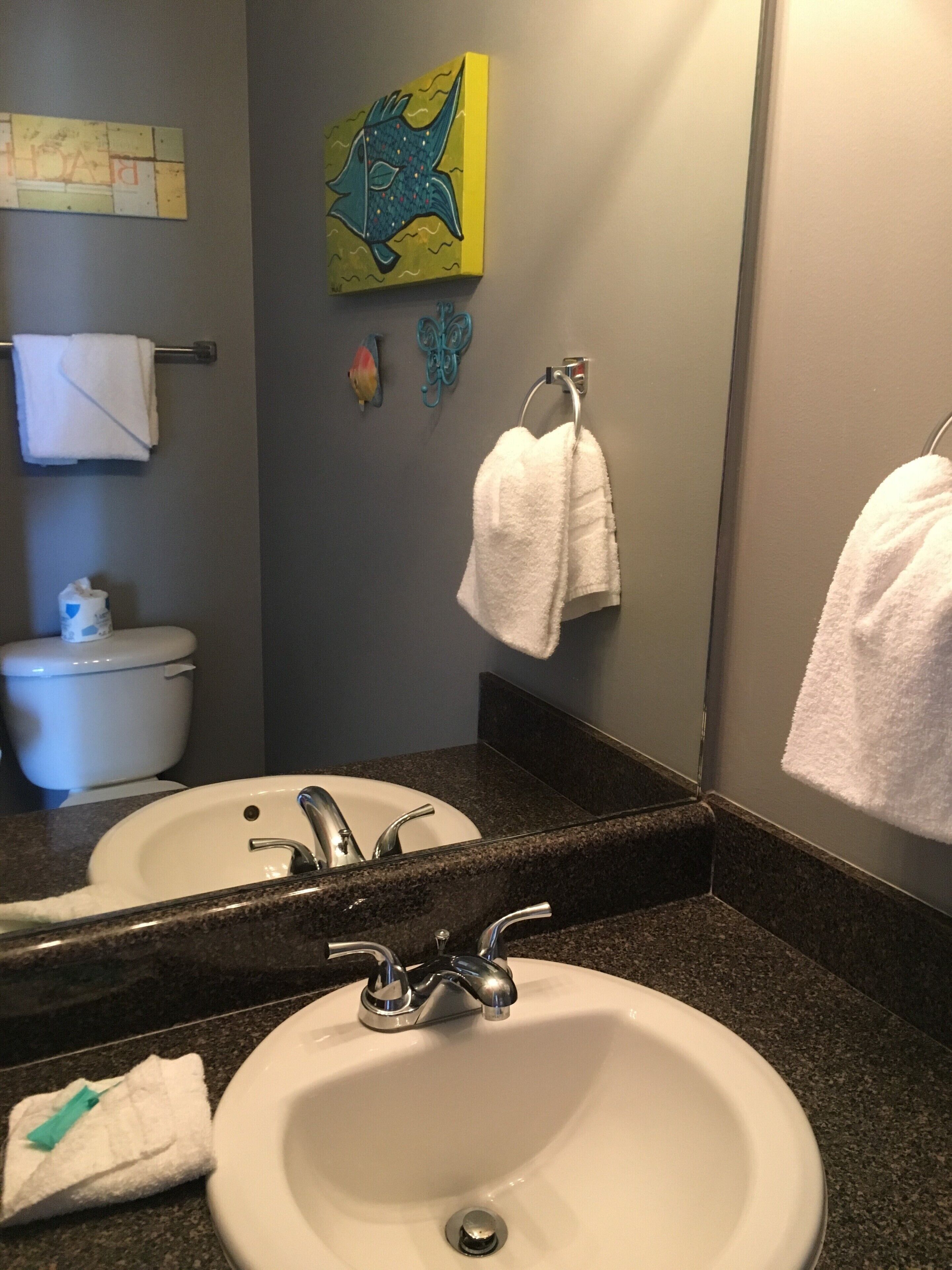 A bathroom with a sink, mirror, and towel rack.