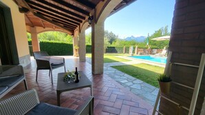 A covered patio with outdoor seating, a pool, and a view of mountains. - Private pool, WIFI, walking distance facilities. Electric car charging point (Castiglione di Garfagnana)