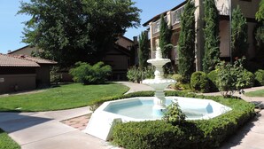 A courtyard with a fountain, surrounded by well-maintained hedges and trees. - Sparkling Newly Remod Condo. Near Zion's, Tuacahn, Bike Trails. Pool &Pickleball (St George)