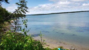 A kayak on a wooden dock by a calm lake with clear water and a forested shoreline. - Large Oceanfront house in Gouldsboro, Maine near Acadia NP; Views! (Gouldsboro)