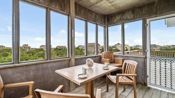 Enjoy a view of the surrounding neighborhood from the deck with a table and chairs.