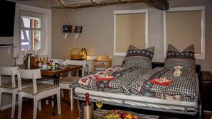 Une chambre confortable avec un lit, une table de chevet et un petit coin repas comprenant des chaises et une table.