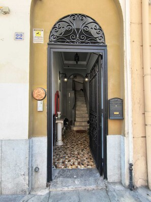 An arched entrance with a tiled floor leading to a staircase.