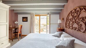 Un dormitorio con una cama grande, un escritorio, una silla y vistas al exterior.