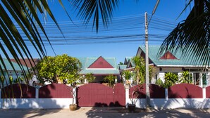 Zona residencial privada con casas, un camino de hormigón y palmeras.
