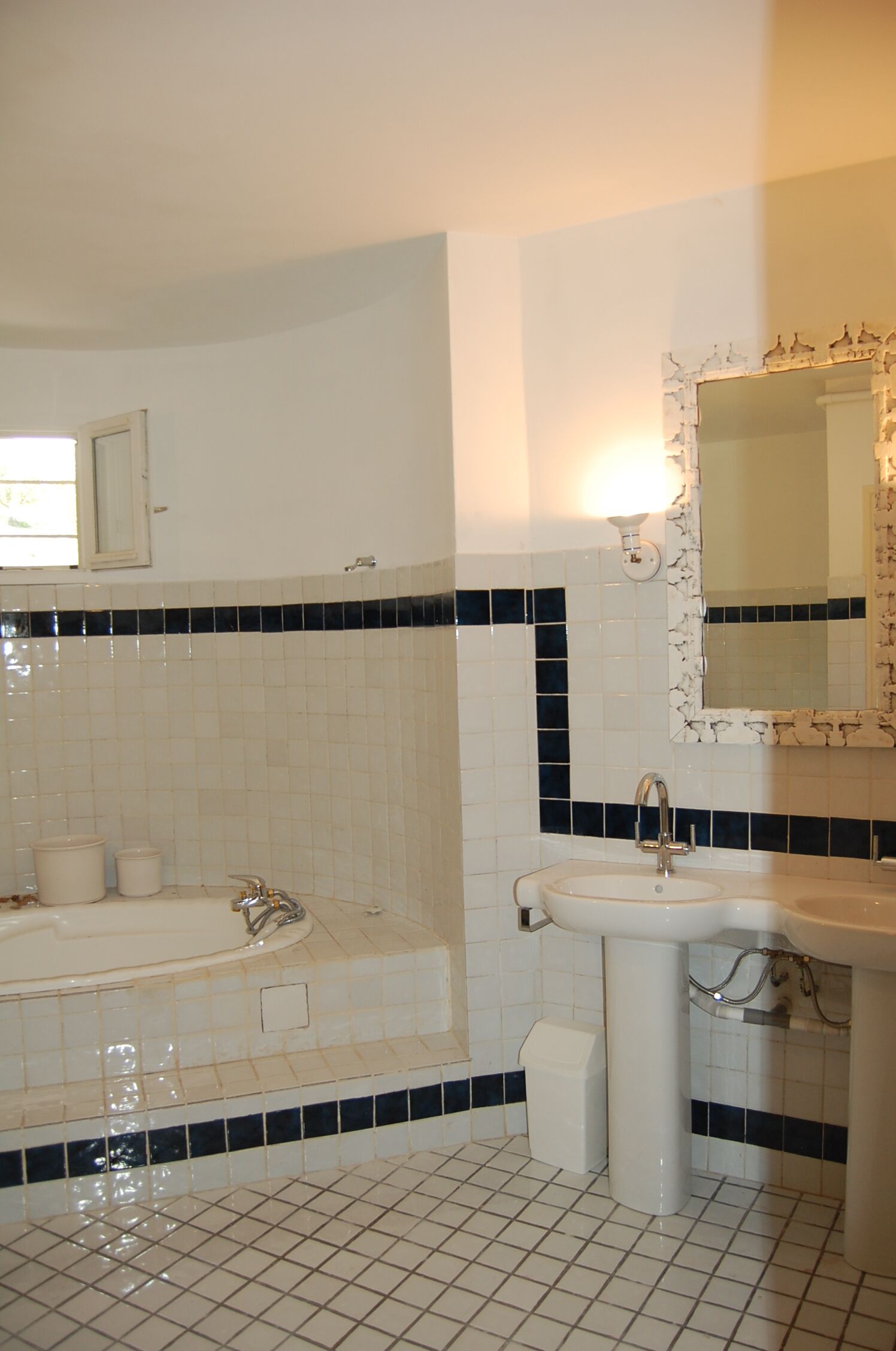 Une salle de bain avec une baignoire, un lavabo et un miroir.