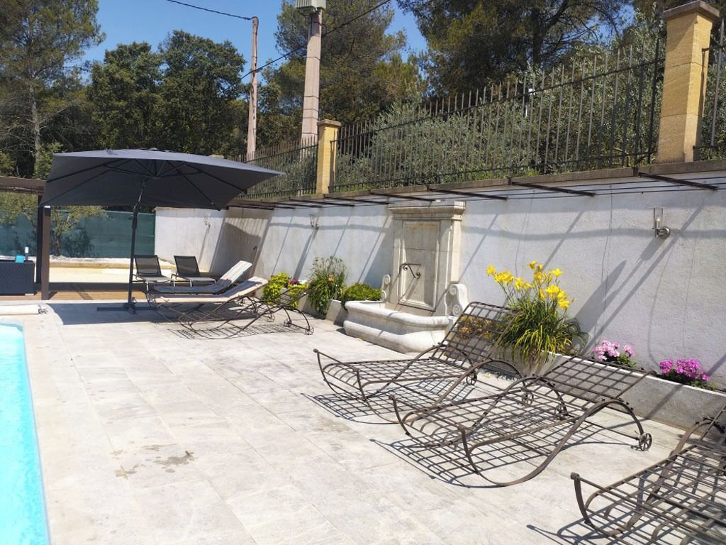 A poolside area with lounge chairs and a covered seating area.
