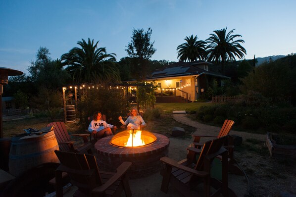 A fire pit with chairs around it, a house in the background, and palm trees. - Wine Country Getaway With Pool, Hot Tub, Garden, Views, Location! (Glen Ellen)