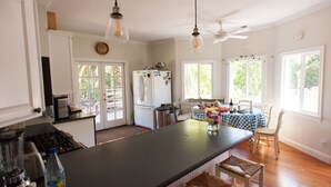 A kitchen with a central island, a dining area with a table and chairs, and a refrigerator.