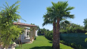 Une maison avec une façade en pierre, un toit en tuiles et une pelouse bien entretenue.