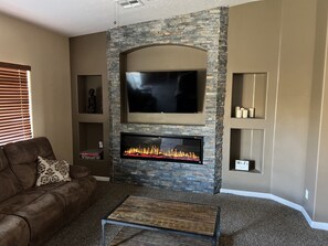 Relax in this cozy living space with a fireplace, flat-screen TV, and comfortable seating area.