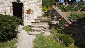 A stone building with a wooden staircase leading to a door labeled "HORNO". - I Poggi di Belvedere (Pieve Santo Stefano AR)