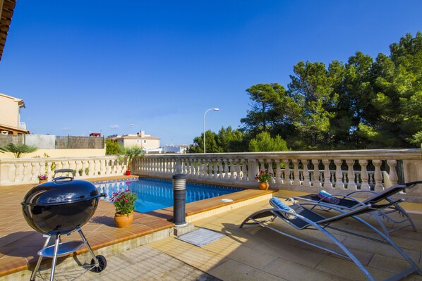 An outdoor pool area with a barbecue grill, lounge chairs, and potted plants. - Villa del Mar / Beach house (Capdepera)