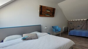 A bedroom with a bed, a chair, a ceiling fan, and a wall-mounted artwork. - Villa 500 m from Ste Marguerite beach (Pornichet)